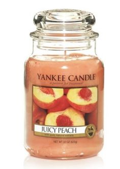 a yankee candle with peaches in it on a white background and the words juicy peach