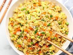 rice and vegetables in a white bowl with chopsticks