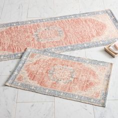 two rugs laying on the floor next to each other, one with an orange and blue design