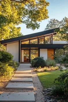 a modern house in the middle of a park with steps leading up to it's entrance