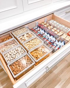 an open drawer in a kitchen filled with lots of nuts and other food items on top of it