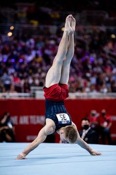 a man is doing a handstand on the floor in front of an audience