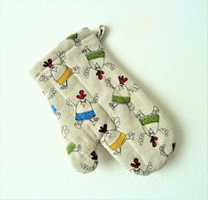 two oven mitts hanging on the wall with cartoon characters all over them and one has a blue, yellow, green, red, white striped tie