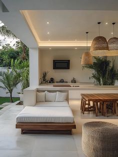 a living room filled with furniture next to a kitchen and outdoor dining area in the background