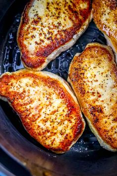 four pieces of chicken in a pan with seasoning