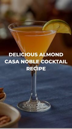 a glass filled with a drink sitting on top of a table next to an orange slice