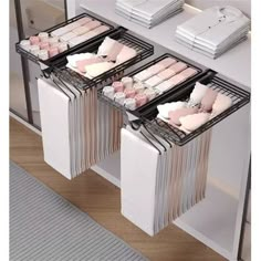 three trays filled with pink and white items on top of a table next to a mirror