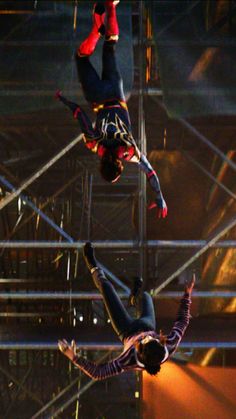 two acrobatic performers performing aerial tricks on stage