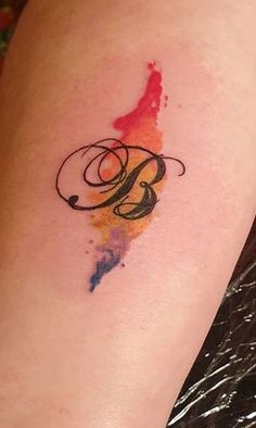 a watercolor tattoo with the letter g on it