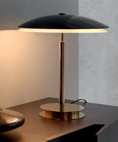 a table lamp sitting on top of a wooden desk