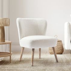 a white chair sitting on top of a rug next to a wooden table and chairs