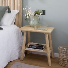 a bedroom with a bed, nightstand and flowers on the end table in front of it