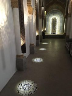 the hallway is lined with decorative tiles and pillars, along with floor coverings that reflect sunlight