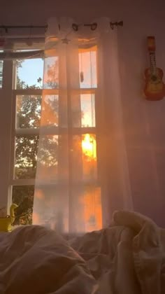 the sun shines brightly through an open window on a bed in front of a white curtain