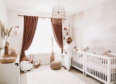 a woman standing in a room with a crib