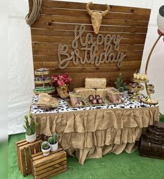 a table topped with cakes and desserts next to a wooden sign