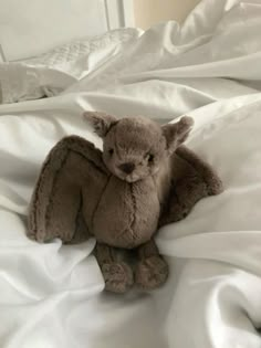 a stuffed animal sitting on top of a white bed