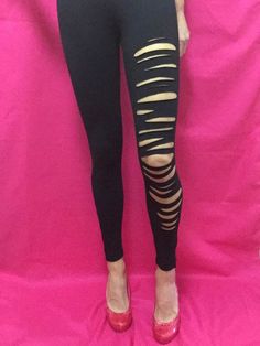 Sleek and chic on the left, ripped and raw on the right, these distressed black leggings with ankle zippers boast the perfect asymmetrical contrast. These one-of-a-kind slashed leggings are staple streetwear at its finest. (Size Small.) Edgy Stretch Bottoms With Holes, Edgy Stretch Leggings, Stretch Ripped Grunge Bottoms, Stretch Ripped Bottoms In Grunge Style, Grunge Style Stretch Ripped Bottoms, Ripped Leggings Diy, Leggings Streetwear, Diy Leggings, Ripped Leggings