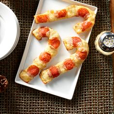 pepperoni pizza on a white plate next to a cup of coffee and silverware