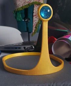 a yellow stand with a blue ball on it's top and some other items in the background