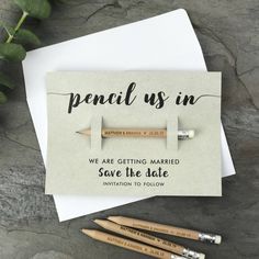 some pencils are laying next to an envelope with the words,'we are getting married save the date '