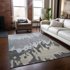 a living room with two couches and a rug in front of a window on top of a hard wood floor