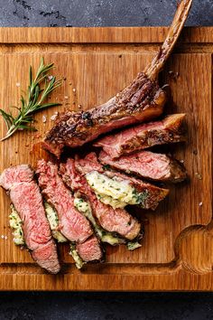 steak on a cutting board with rosemary garnish