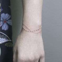 a woman's hand with a tiny bracelet on it