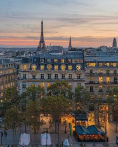 the eiffel tower in paris is lit up at night with people walking around