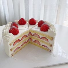 a cake with white frosting and strawberries on top is cut into four pieces