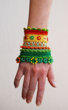 a person's hand with beaded bracelets on their wrists and wristbands