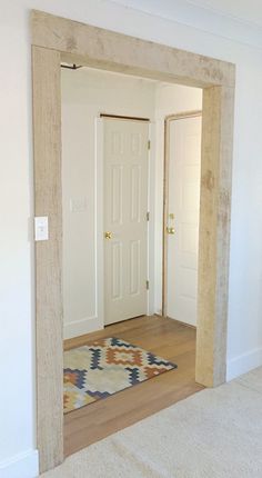 an empty room with a door and rug on the floor