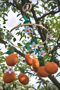 an orange and flower mobile hanging from a tree