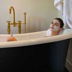 a woman laying in a bathtub with her eyes closed