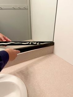 a person is brushing their teeth in front of a mirror with black and white strips