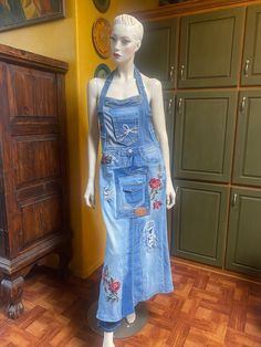 a mannequin dressed in overalls stands next to a dresser