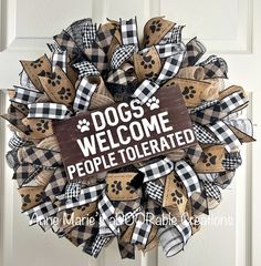 a dog welcome sign is hanging on the front door with black and white checkered ribbon