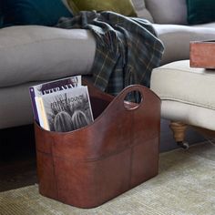 a brown leather magazine holder sitting on top of a rug