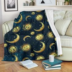 a blanket with the sun and moon on it is sitting next to a stack of books