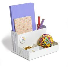 a white desk organizer with pens, pencils and balls in the bottom drawer on a white background