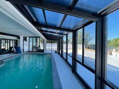 an indoor swimming pool with glass walls and sliding doors