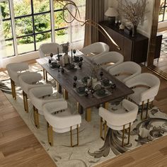 a dining room table with white chairs around it