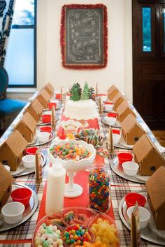 a table is set up for a holiday party with candy and cookies on the table