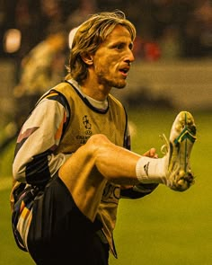 a man holding a soccer ball in his right hand and wearing a catchers mitt