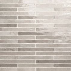 a close up view of a white brick wall with grey grouting on it