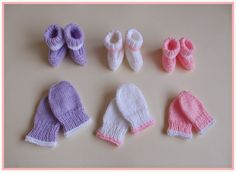 several knitted baby mittens and gloves laid out on a table