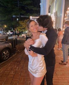 a man and woman are hugging on the street