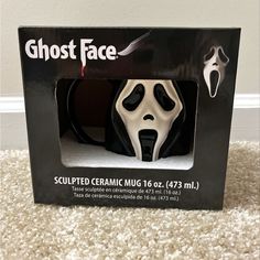 a black and white box with a ghost face in the front on carpeted area