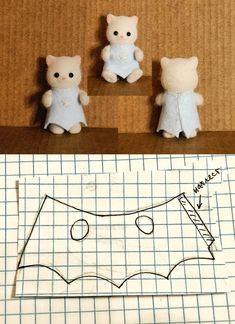 three stuffed animals sitting on top of a piece of paper next to a cut out pattern