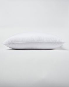 a white pillow sitting on top of a bed